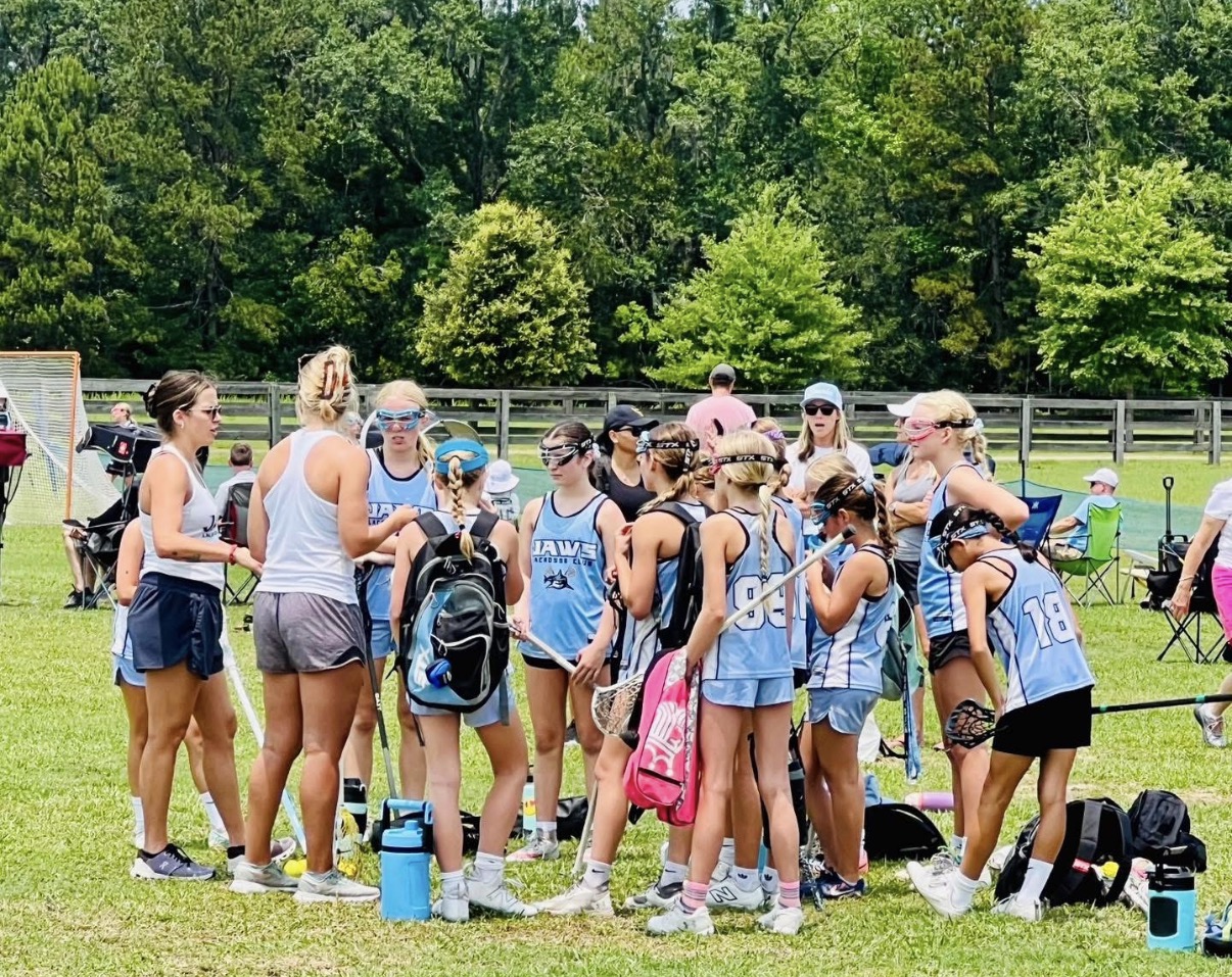 Girls Jaws team gathered with coaches on the sideline