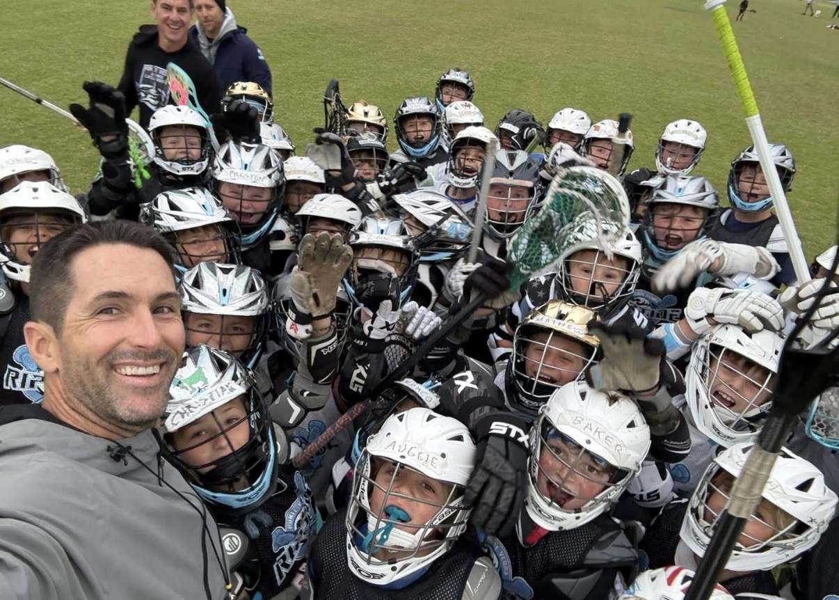 Ponte Vedra coach surrounded by young lacrosse players